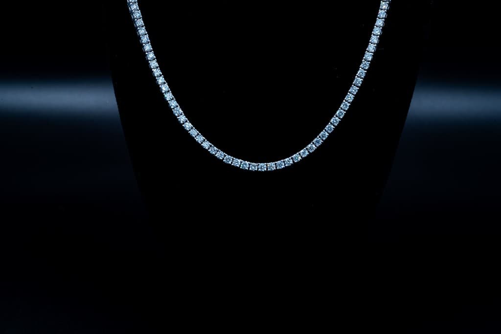 Diamond tennis necklace on a black jewelry bust